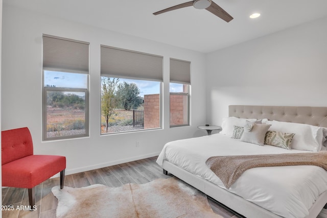 bedroom featuring recessed lighting, multiple windows, wood finished floors, and baseboards