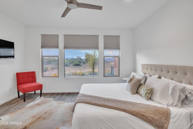 bedroom featuring baseboards, a ceiling fan, and wood finished floors