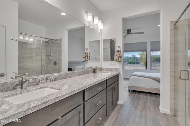 ensuite bathroom with a stall shower, a sink, a ceiling fan, and ensuite bath