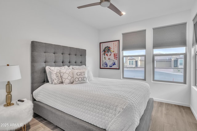 bedroom featuring ceiling fan, baseboards, and wood finished floors
