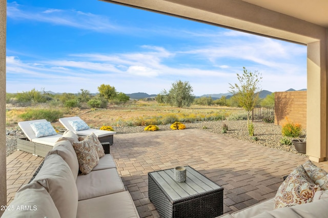 view of patio / terrace with fence, outdoor lounge area, and a mountain view