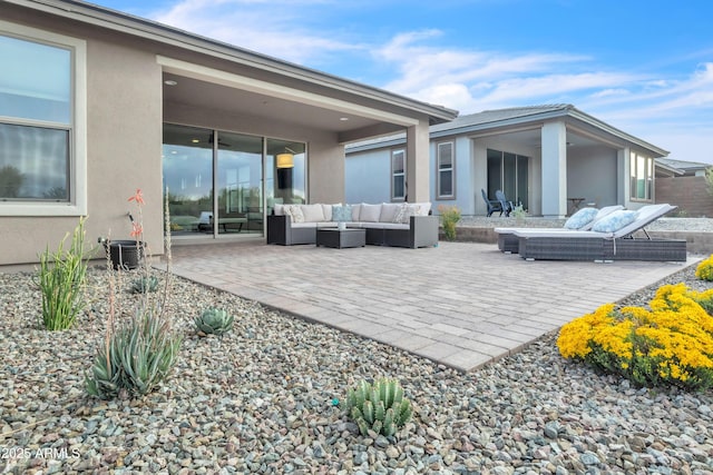 rear view of property with outdoor lounge area, a patio, and stucco siding