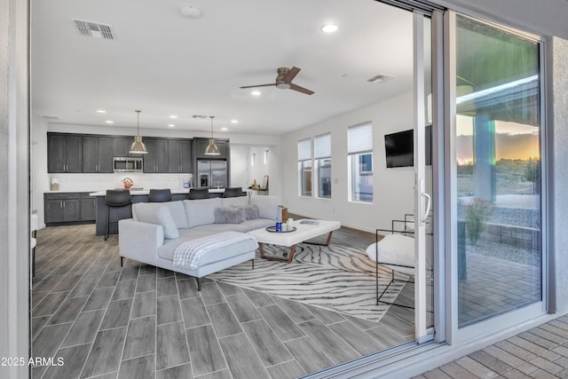 living area featuring visible vents, ceiling fan, and recessed lighting