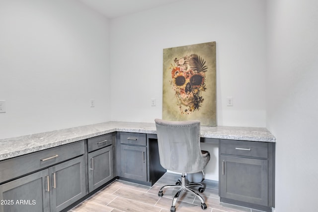 unfurnished office featuring built in study area and light wood finished floors