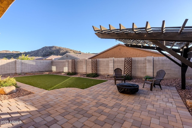 view of patio / terrace with an outdoor fire pit, a pergola, and a mountain view