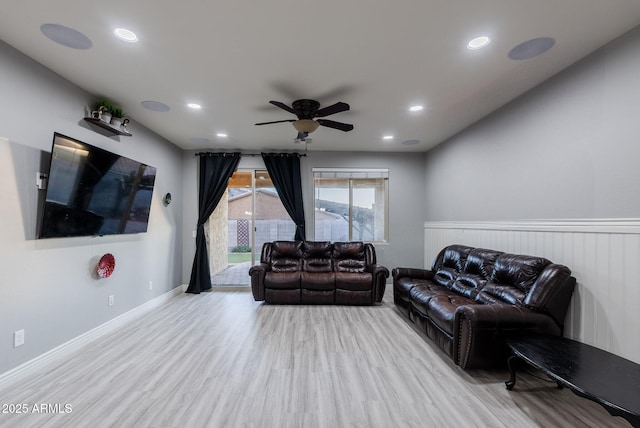 living room featuring ceiling fan and light hardwood / wood-style flooring