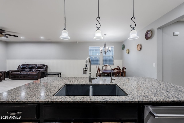 kitchen featuring hanging light fixtures, sink, and an island with sink