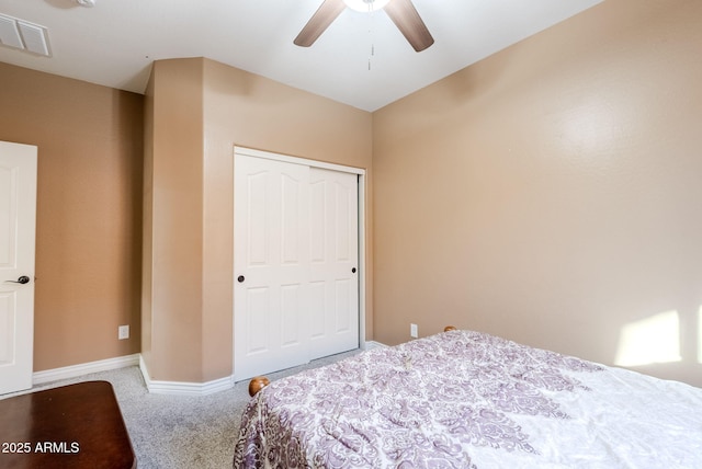 carpeted bedroom with ceiling fan and a closet