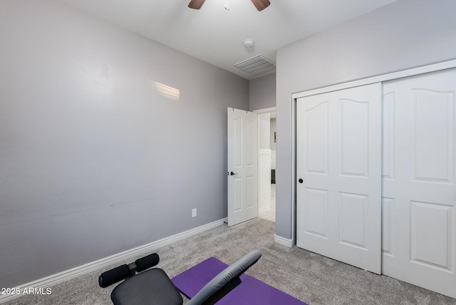 workout room featuring ceiling fan and light colored carpet