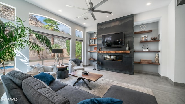 living room featuring a large fireplace, recessed lighting, visible vents, and baseboards