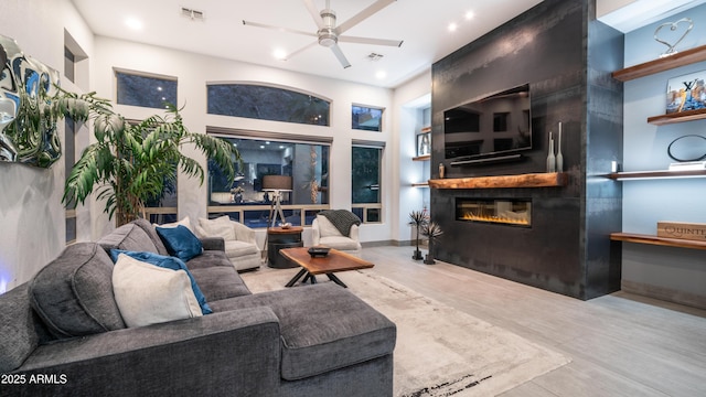 living area with ceiling fan, a fireplace, and visible vents