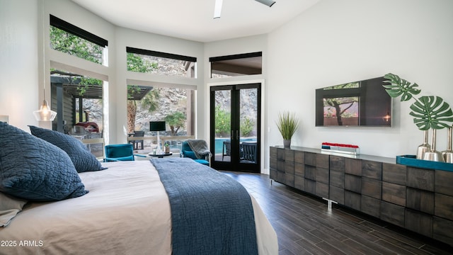 bedroom with a towering ceiling, access to exterior, dark wood-type flooring, and french doors