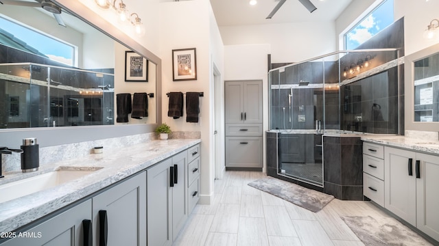 bathroom with a shower stall, two vanities, and a sink