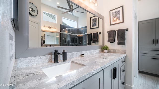 full bath with a shower stall, ceiling fan, and vanity