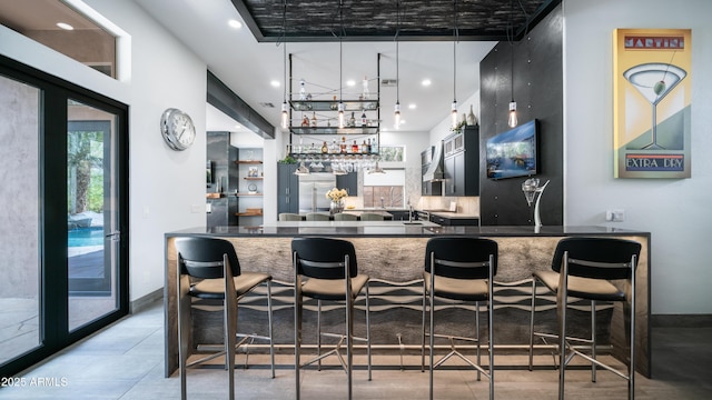 bar with baseboards, stainless steel built in fridge, recessed lighting, and wet bar