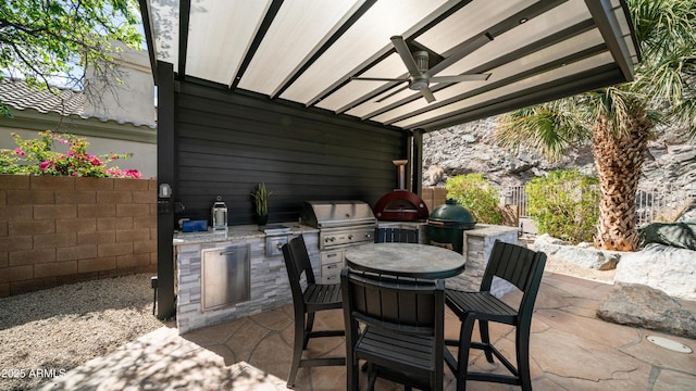 view of patio with grilling area, area for grilling, a ceiling fan, outdoor dining space, and fence