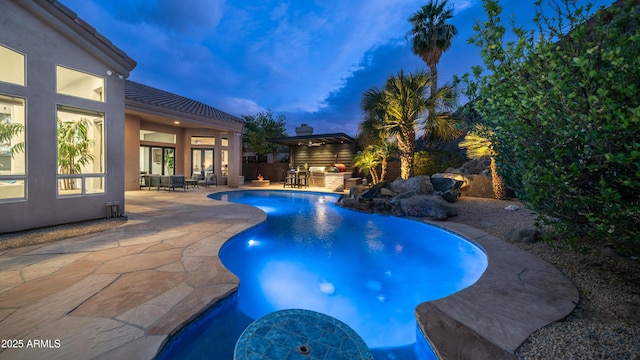 pool at dusk featuring fence, an outdoor pool, area for grilling, and a patio