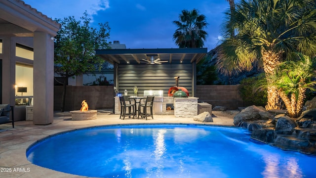 view of swimming pool with area for grilling, an outdoor fire pit, a patio area, ceiling fan, and a fenced backyard