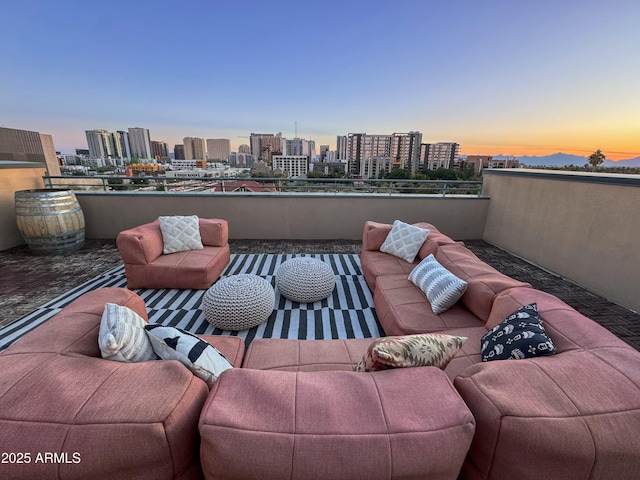 patio terrace at dusk featuring a balcony