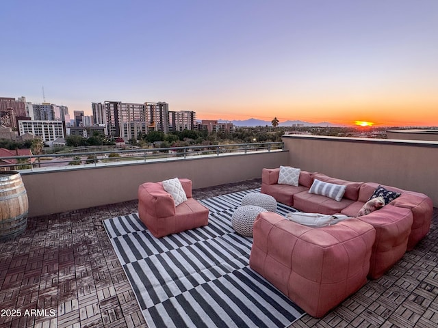 patio terrace at dusk featuring a balcony and an outdoor living space