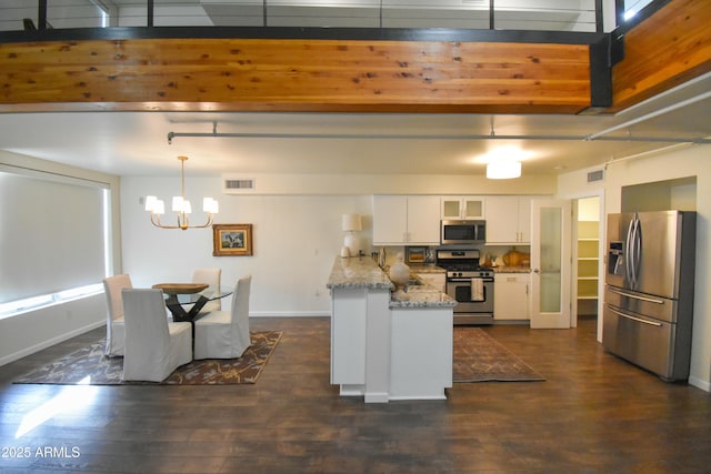 kitchen featuring white cabinetry, hanging light fixtures, appliances with stainless steel finishes, and dark wood-type flooring