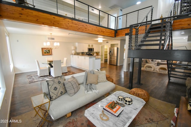 living room with a high ceiling, dark hardwood / wood-style floors, and a notable chandelier