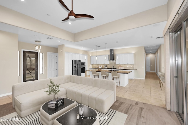 living area featuring baseboards, light tile patterned floors, a ceiling fan, and recessed lighting