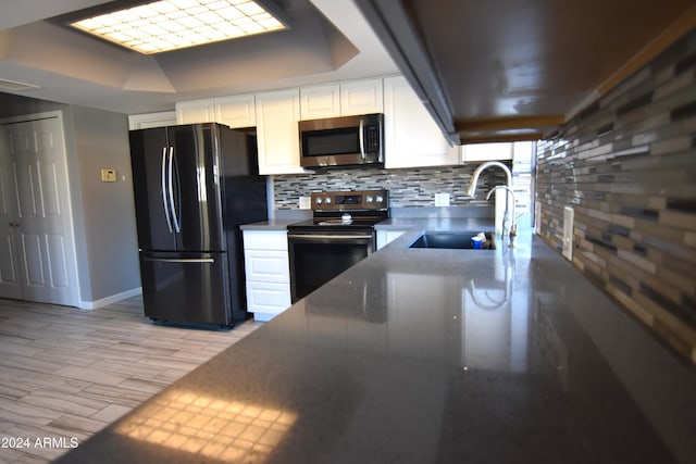 kitchen featuring sink, white cabinets, stainless steel appliances, and decorative backsplash