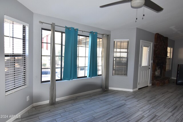 spare room with ceiling fan, light hardwood / wood-style floors, and a healthy amount of sunlight