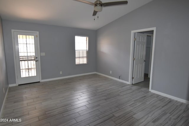 empty room featuring light wood-type flooring, vaulted ceiling, and ceiling fan