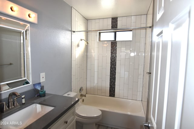 full bathroom featuring tiled shower / bath combo, vanity, and toilet