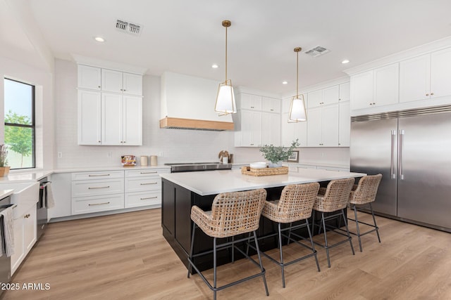 kitchen with white cabinetry, a center island, pendant lighting, and appliances with stainless steel finishes