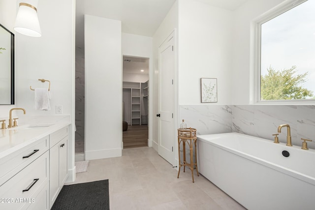 bathroom with a bath, vanity, and tile patterned floors