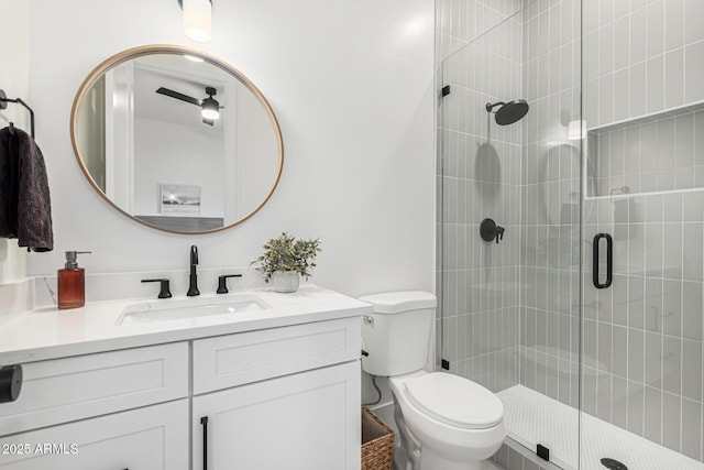 bathroom featuring vanity, toilet, and a shower with door