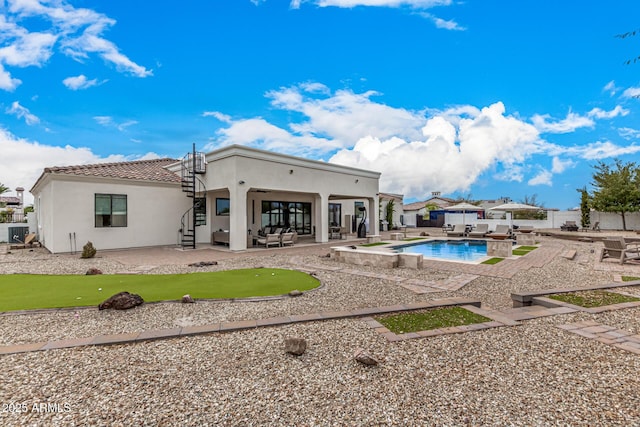 back of property featuring a patio area, an outdoor hangout area, and a fenced in pool