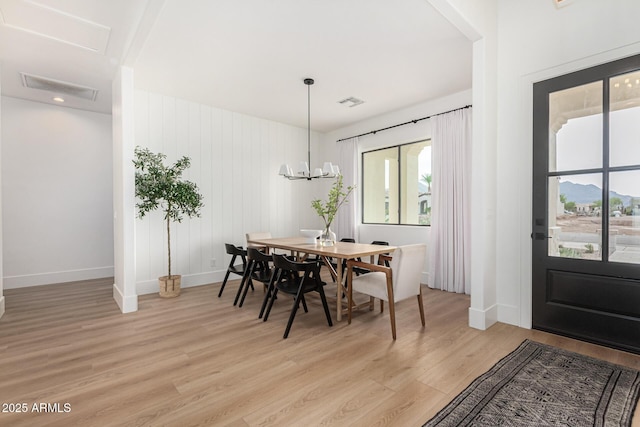 dining space featuring an inviting chandelier and light wood-type flooring