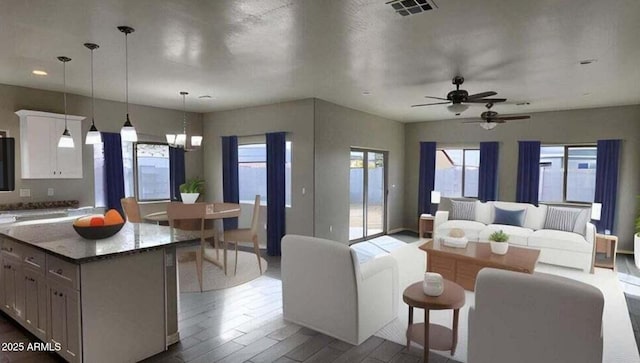 kitchen with a kitchen island, a wealth of natural light, decorative light fixtures, white cabinetry, and hardwood / wood-style flooring