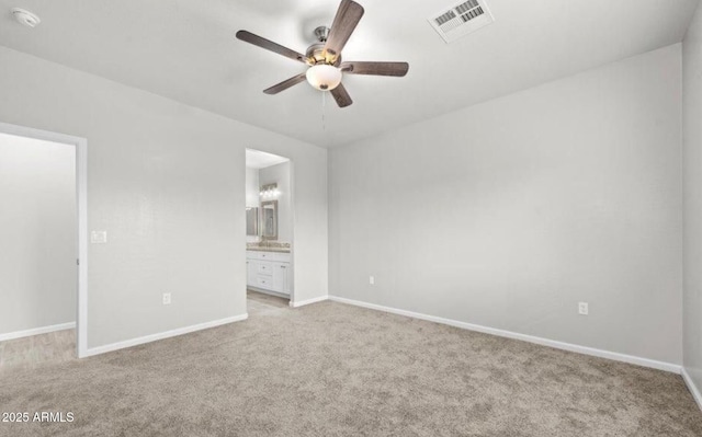 unfurnished bedroom with ceiling fan, light colored carpet, and connected bathroom