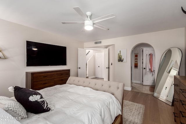 8807 E Dahlia Dr, Scottsdale, AZ 85260 - bedroom featuring ceiling fan, baseboards, arched walkways, and hardwood / wood-style floors