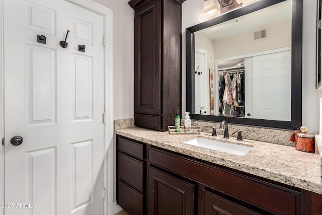 8807 E Dahlia Dr, Scottsdale, AZ 85260 - bathroom with vanity, a spacious closet, and visible vents