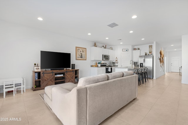 living room featuring sink and light tile patterned floors