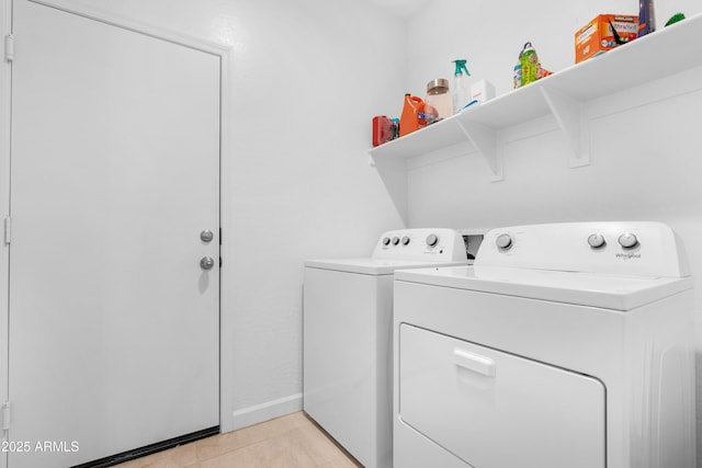 laundry room with washer and dryer and light tile patterned floors