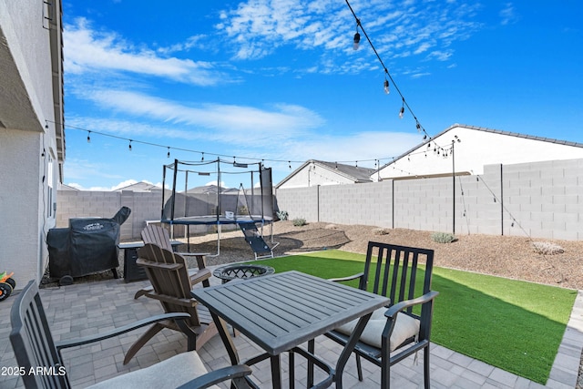 view of patio with a trampoline and a grill