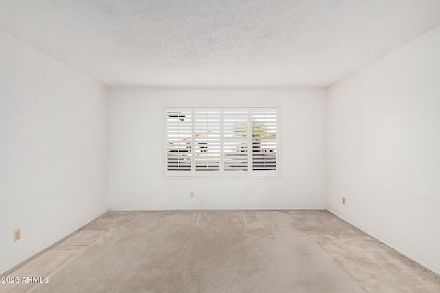 carpeted spare room featuring a textured ceiling