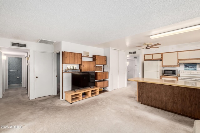 kitchen featuring white appliances, ceiling fan, visible vents, and extractor fan