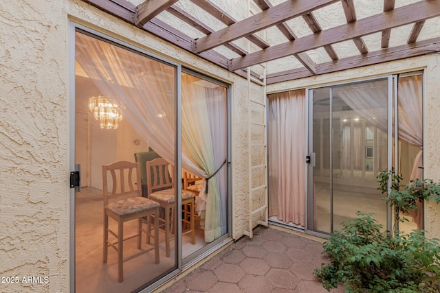 doorway to property with a pergola and stucco siding