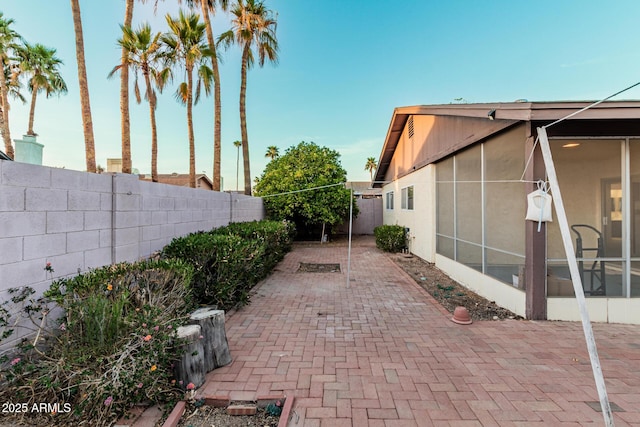 view of patio with a fenced backyard and a sunroom