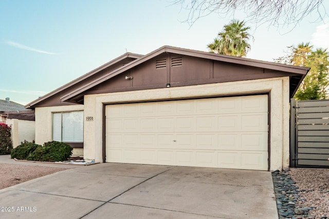 view of front of home featuring an attached garage, concrete driveway, and stucco siding