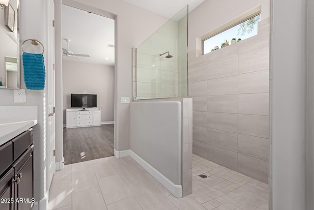 bathroom with ceiling fan, vanity, tile patterned flooring, and a tile shower