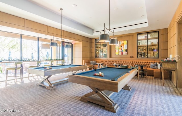 rec room with billiards, wood walls, a tray ceiling, and carpet flooring